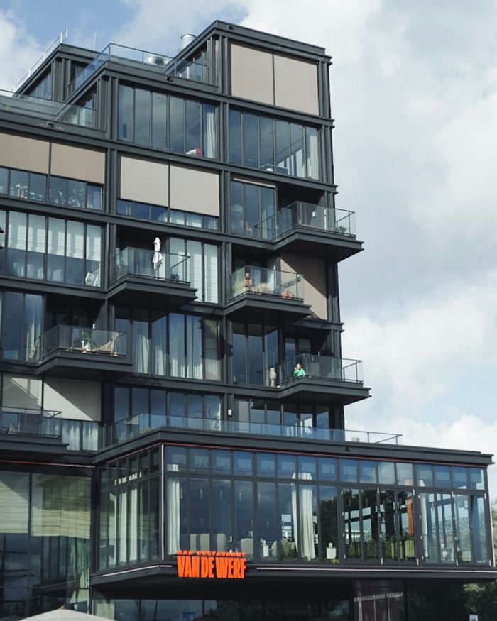 Modern urban apartment building with glass facade and balconies.